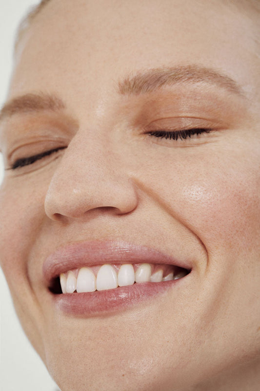 Retrato de mujer con ojos cerrados y sonrisa inocente